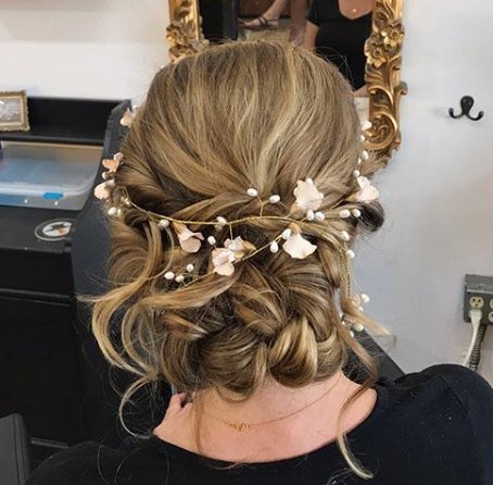 Textured bridal updo with a pearl and flower vine